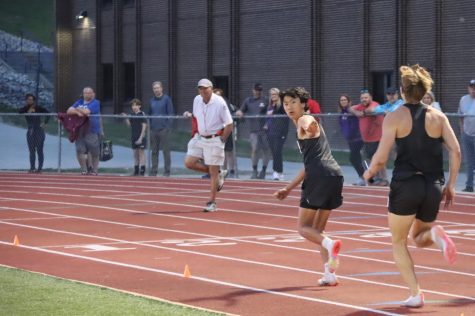 Preparing to start his leg, freshman Kai Han receives the baton from senior Marshall Ems in the 4x400-meter race. Juniors Dillon Cronin and Jack Robeson, along with Ems and Han, won the 4x400-meter relay at the Suburban Conference Meet.