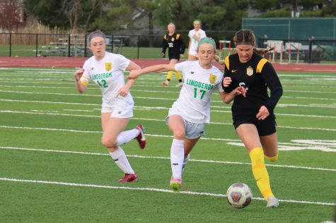 Fending off the Lindbergh player, freshman Carly Swan dribbles the ball. Swan scored twice in the Lady Lancers championship game against North Point.