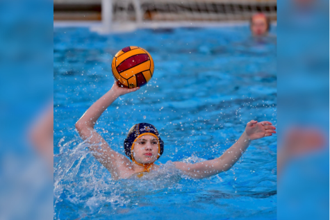 Holding the ball above his head, freshman Owen Waeckerle scans the pool for a pass. Last summer, Owen participated in the Junior Olympics, held in Dallas, where teams across the country compete for a gold medal.