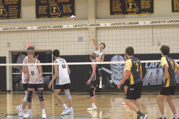 Junior Ethan Tran serves the ball in a game against Seckman High School on April 6. They swept Seckman 3-0, with Tran leading the team in aces and serves. Overall, the Lancers placed second in the State Championship last season.