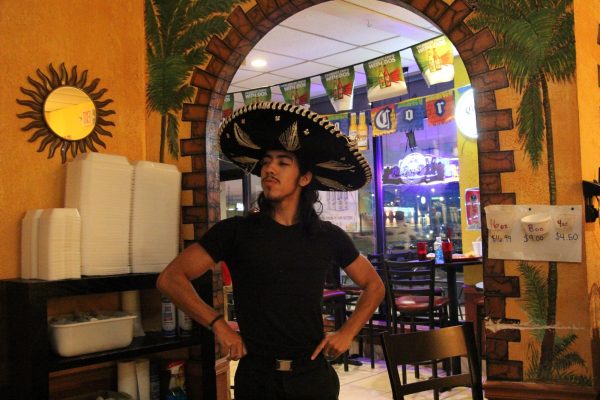 At the entrance to El Nopal, junior Nicolas Kuehnel wears a traditional sombrero. Kuehnel is a waiter at El Nopal.