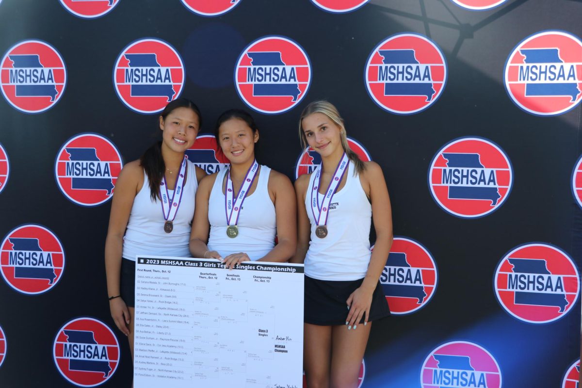 Holding the tournament bracket, senior and State champion Amber Yin stands next to All-State doubles teammates sophomore Mia Yin and freshman Mary Sublette. Amber won State without dropping a set and the doubles team of Mia and Sublette placed 5th.