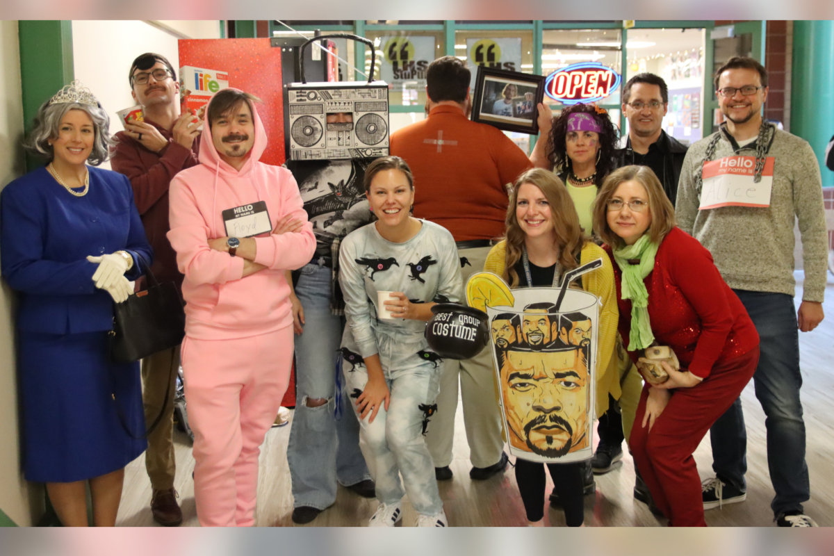 Showing off their trophy, the Fine Arts Department poses for a photo after winning the Staff Halloween Costume Contest. After other staff members and departments displayed their costumes the Fine Arts Department came out on top, taking the win. 
