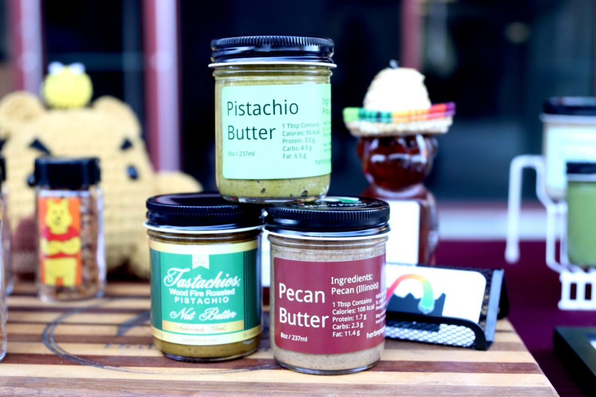 On his personalized cutting board, Herb N Pepper owner Anthony Lynch displays his three best selling nut butters. Lynch said his butters are typically unique at these markets due to his combinations and the fact that he uses garlic.