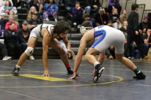 Hand on the mat, senior Aiden Schoen faces off against his Seckman opponent, Jan 6, 2024. Schoen placed 4th at State last year and is a player to watch in the upcoming season.