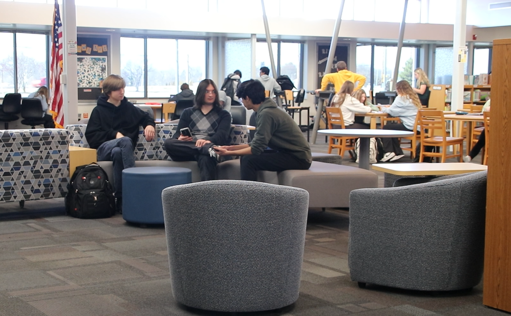 Following the librarys first stage of new furniture, juniors Baron Czymmek, Gavin Kiefer, and Soham Vij use the librarys center piece.
