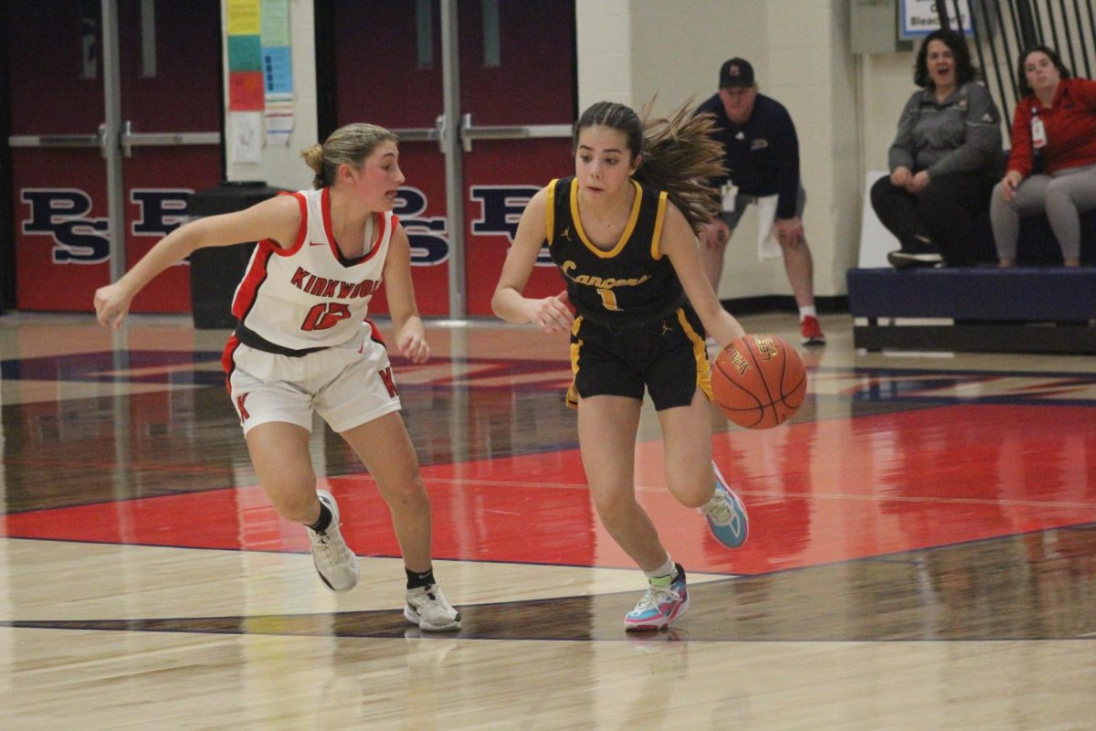 With+a+defender+on+her+hip%2C+freshman+Lylah+Kimberlin+drives+down+the+court+in+the+MSHSAA+District+Quarterfinal.+The+Lady+Lancers+would+go+on+to+lose+this+game+against+Kirkwood+59-34.