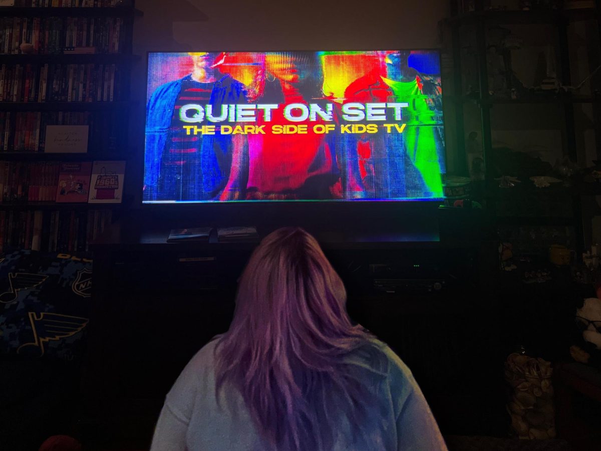 In front of her TV, junior Maddy Cox stares at the opening screen of the docuseries Quiet on Set. The docuseries featured Nikelodeon cast and crew members talking about abuse they went through while working on and off set.