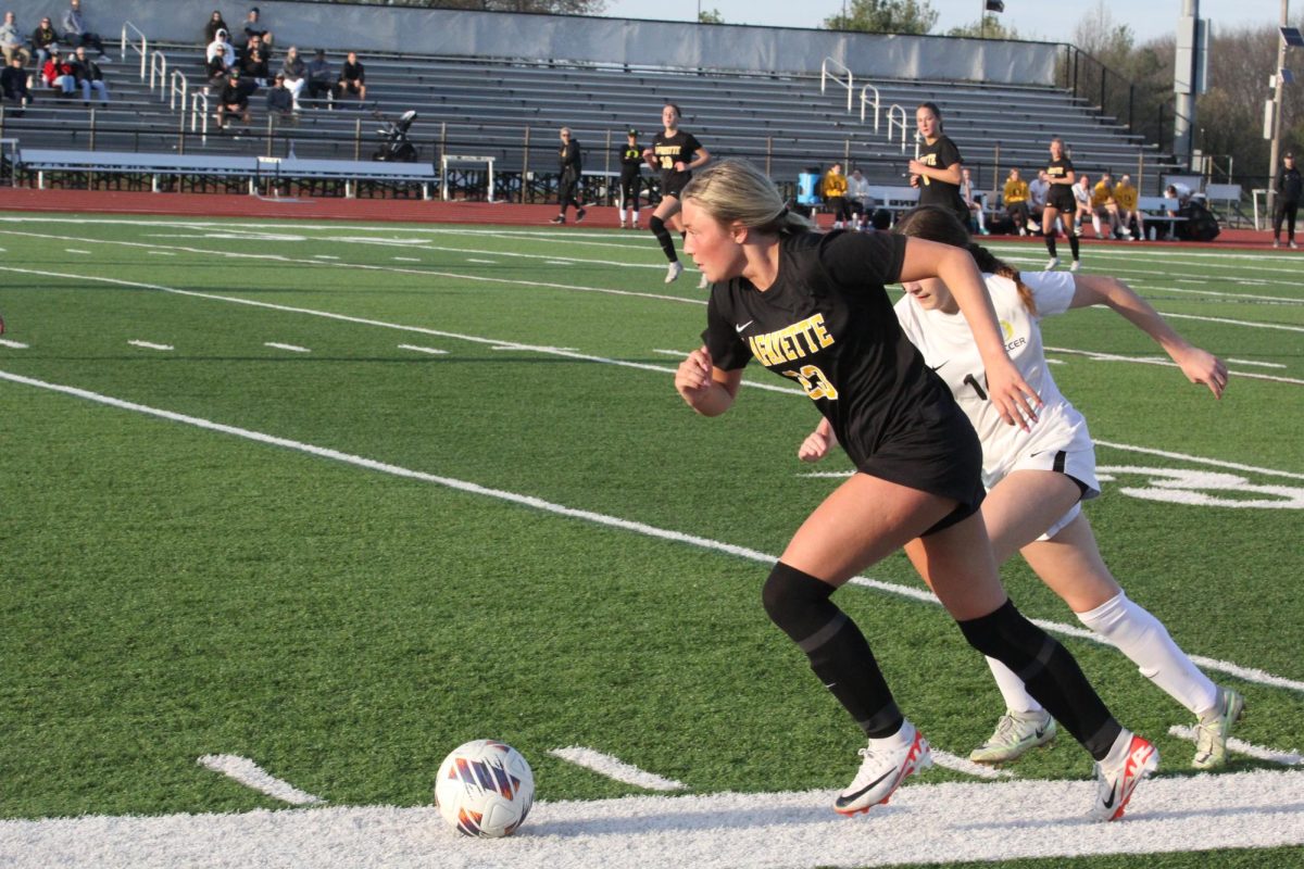 Eyes looking upfield, senior Emily Derucki brushes by her defender. Earlier this year, Derucki received the Bob Kehoe Future Star Award from the St. Louis Soccer Hall of Fame. Derucki leads the team with 4 goals so far this season. 