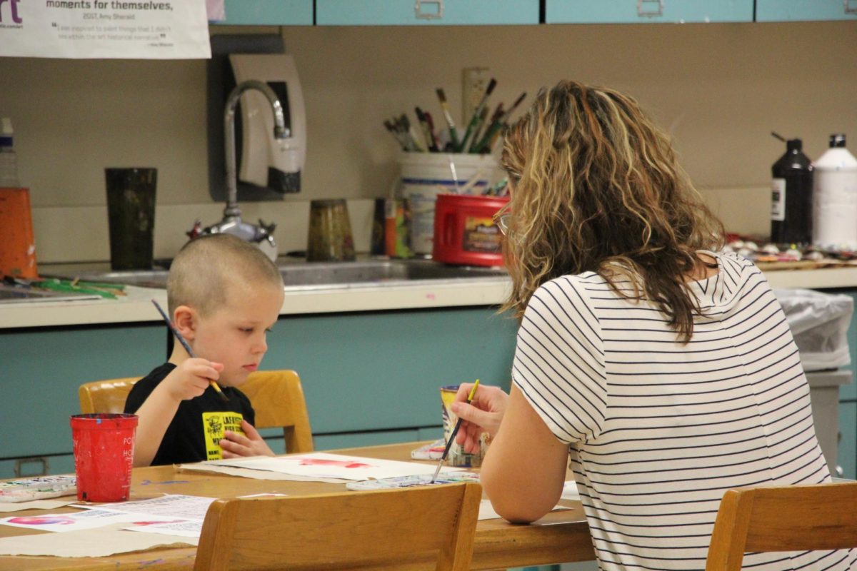 Math teacher Emily Pestka paints with her son, Jackson. Its fun for [him] to get to see what my day is like and for him to help me a little bit, Pestka said.