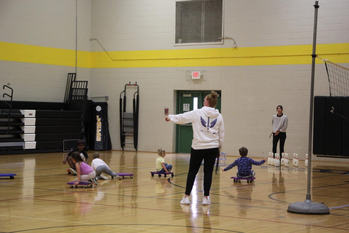 At the beginning of 6th Hour, PE teacher Megan OConnell helps lead a game of scooter soccer in the Back Gym. 