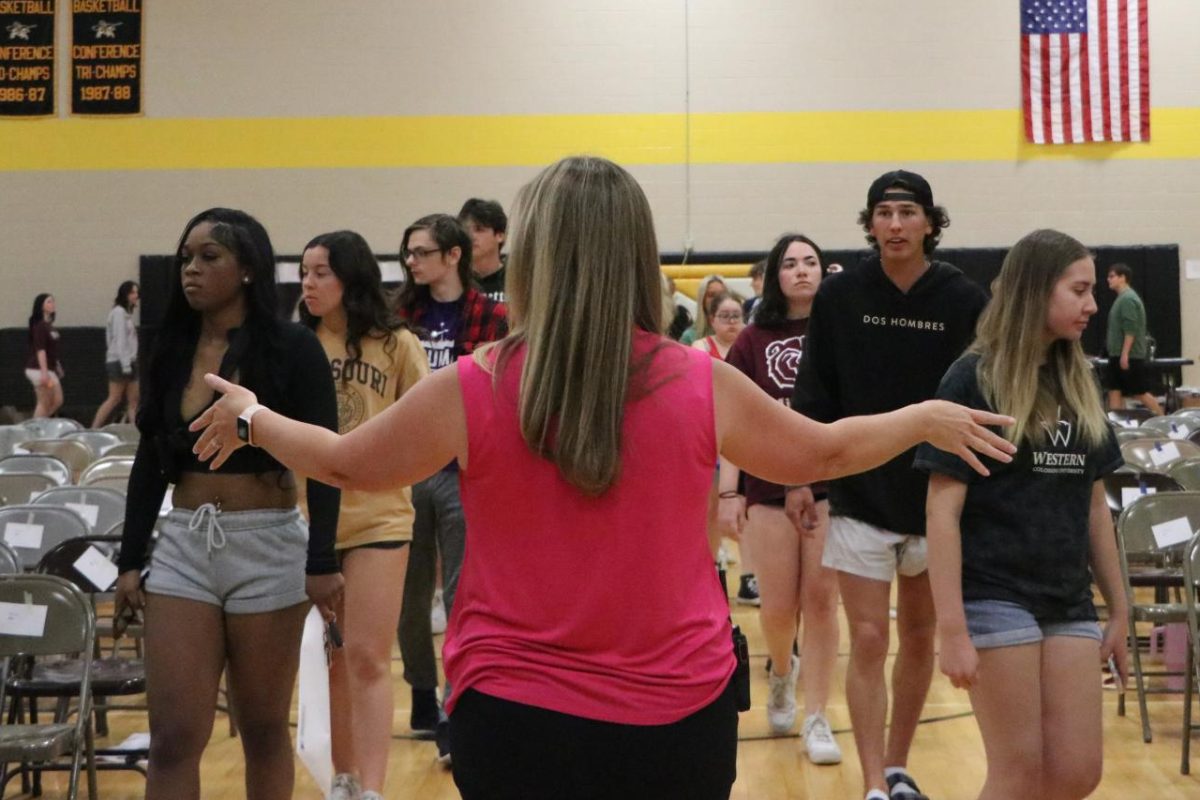 During Graduation Practice for the Class of 2023, Assistant Principal Mandy Lewis helps guide students to their assigned seats. This year, Graduation Practice will be held May 10.