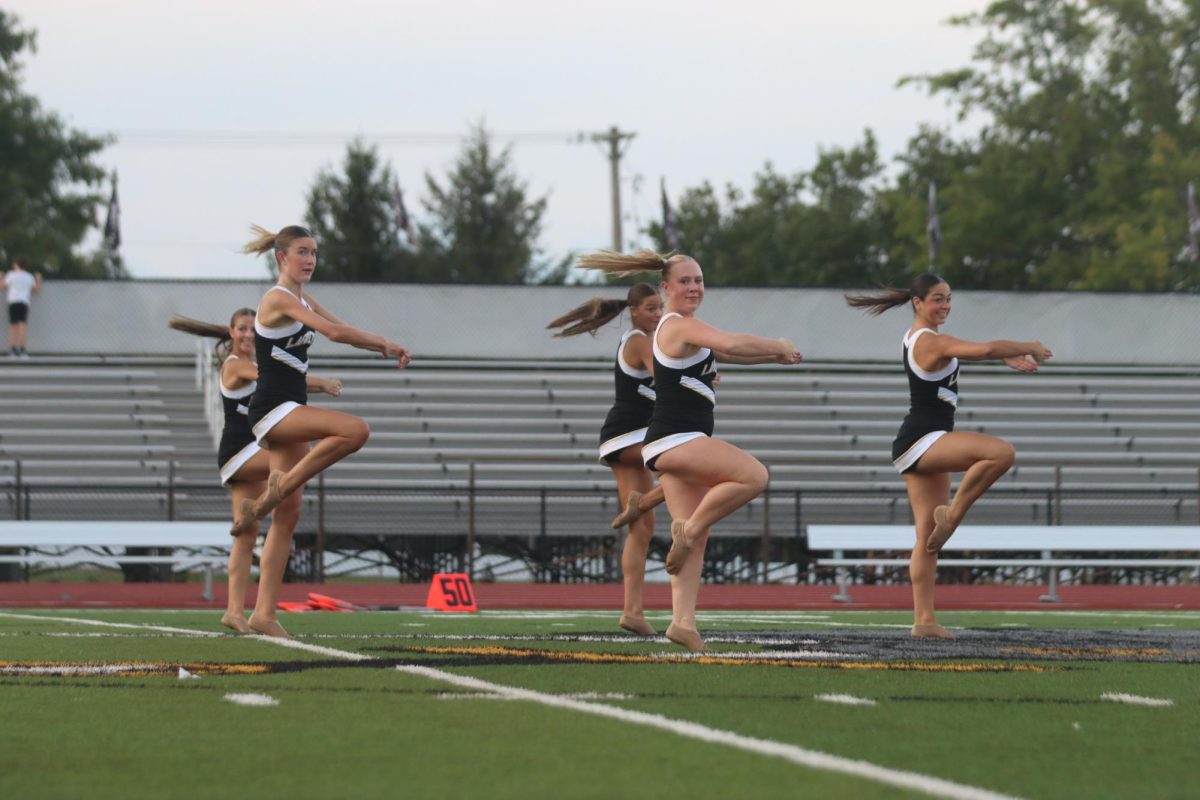 Varsity Escadrille captain senior Jessie Kennington, along with senior Elle Kuelker and sophomore Milena Mendonca perform their routine called "Let's Get Glam."