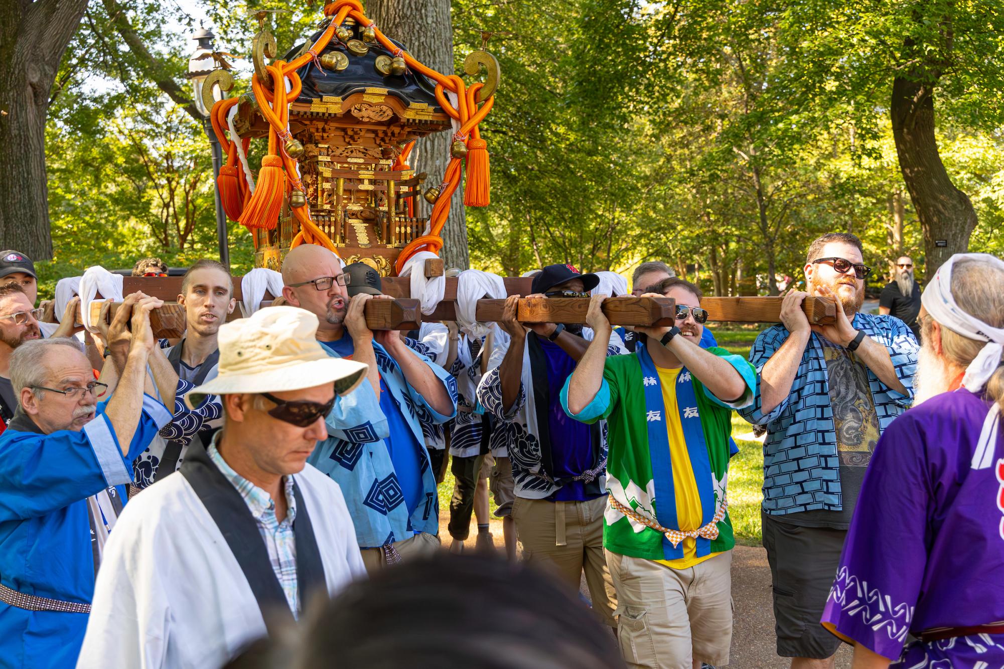 To guide the festival float pulled by Japanese students, attenders carry the Omikoshi shrine through the Botanical Gardens.