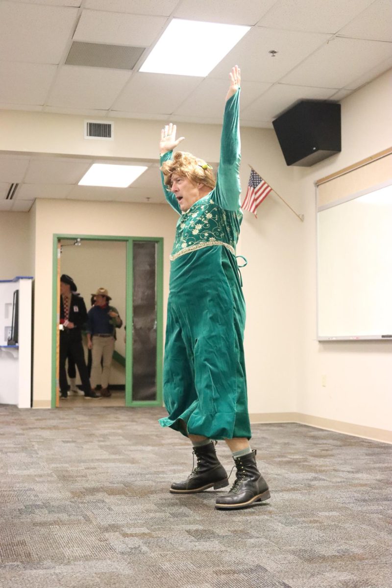 Dressed as Fiona the Ogre from "Shrek", Staff Sergeant Matt Zahradka leads staff in the "YMCA".