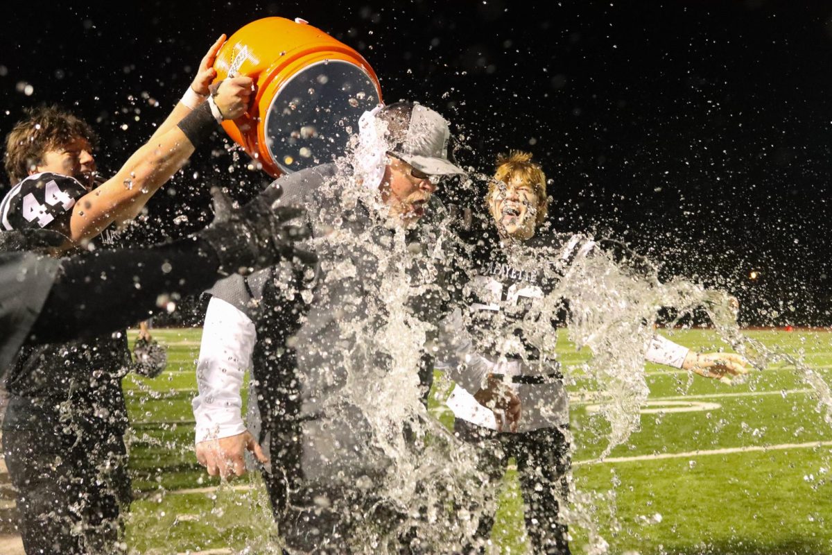 Senior linebacker Nathan Hutchison and senior defensive back Drew Austermann dump water on coach Boyd Manne to celebrate the win. Lafayette became District champions for the first time since 2012.