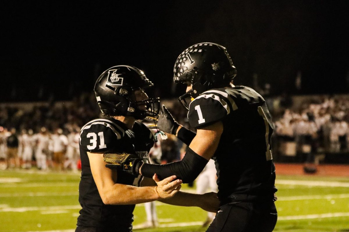 Senior linebacker Alex Behl celebrates with senior receiver Robby Preckel after a touchdown.