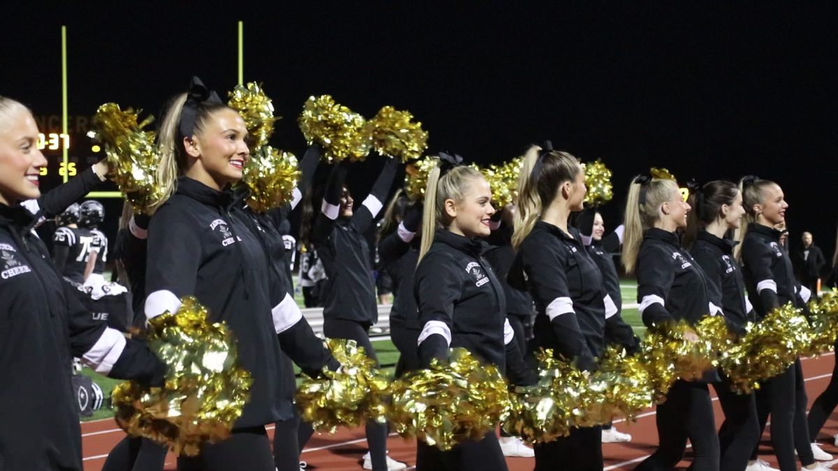 The cheerleaders cheer on the football players during the crucial district game against the Washington Blue Jays. The night ultimately led to a win for the Lancers.