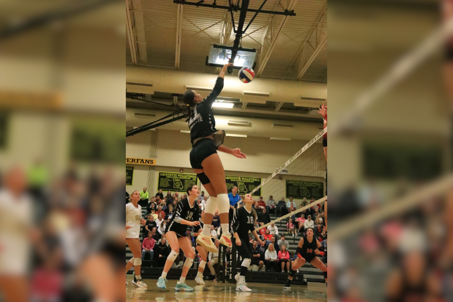 Sophomore outside hitter, Shaye Witherspoon jumps into the air for a kill. 