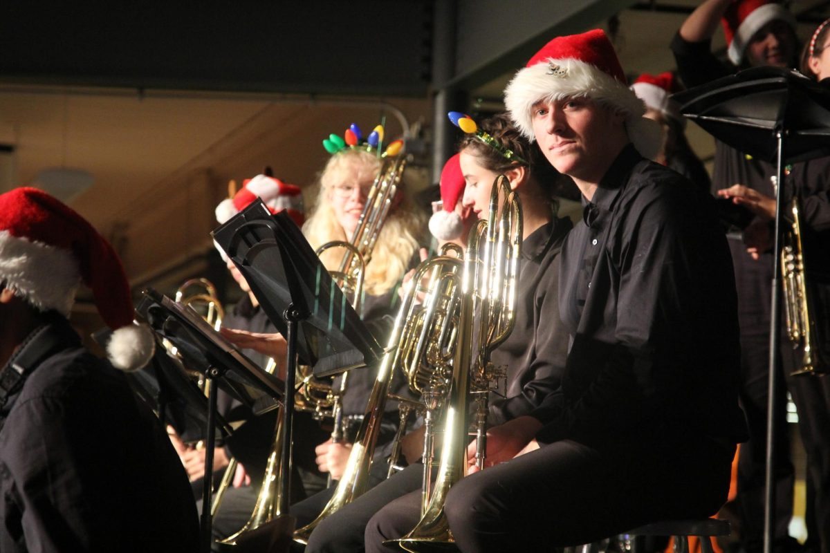 After the MIOS concert, Jazz Band members wear Christmas attire while setting up to perform on the Commons stage.