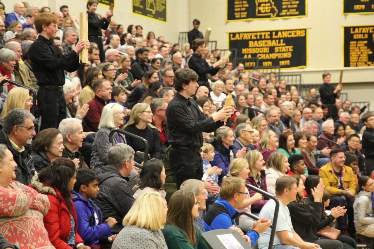 During "Sleigh Ride" sophomore Jacob Tate and freshman Charlie Heger hold their slap-sticks, awaiting their cue from music teacher Kevin Lowe.