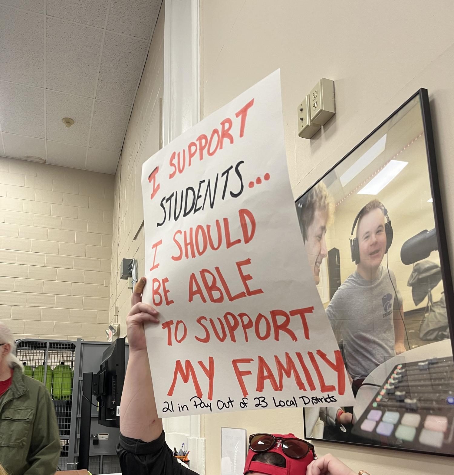 During the Nov. 7 BOE meeting, a Rockwood staff member silently holds up a sign stating "I support students, I should be able to support my family. 21  in pay out of 23 local districts."