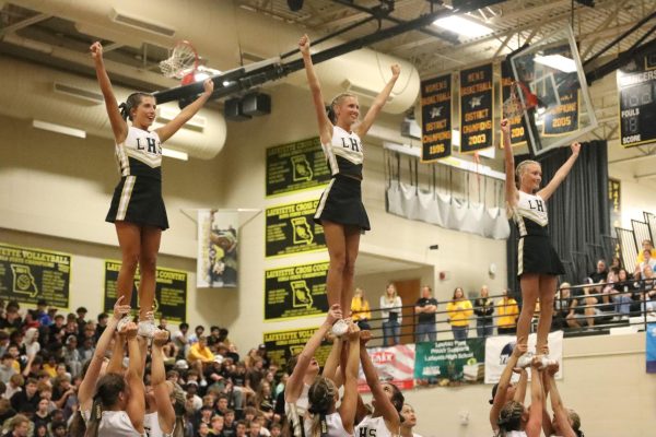 During the homecoming pep assembly, junior Mackenzie Kannel, senior Abby Moyer, and junior Rylee Keim get ready for a stunt.