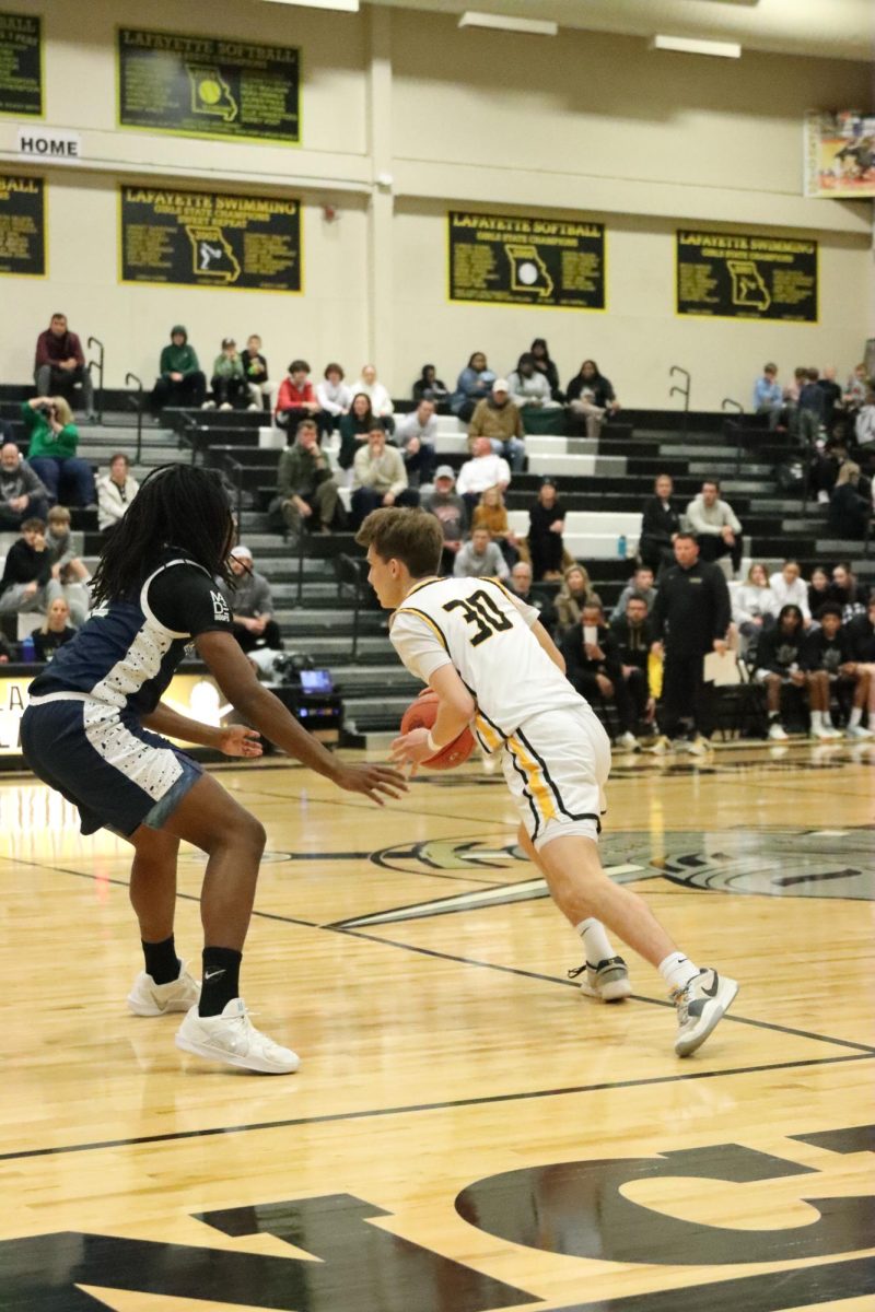 Senior guard Josh Pitney dribbles past Marquette defender