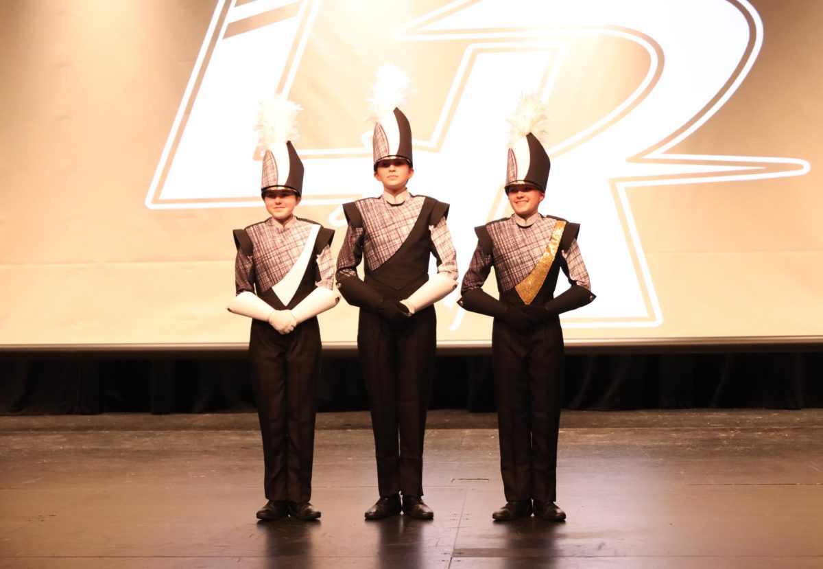 Lancer Regiment members Avery Holder (left), Meghan McKee (center) and Sarah Morrison (right) model new marching band uniforms. The new uniforms were revealed on March 13, 2024 in the Theater.