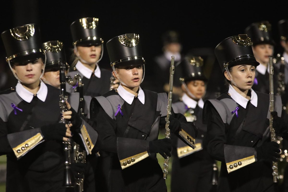 Lancer Regiment members march in their 2024 marching band show Masterpiece at the football game against Eureka. Purple ribbons were worn to honor a Eureka band student who had recently passed away.