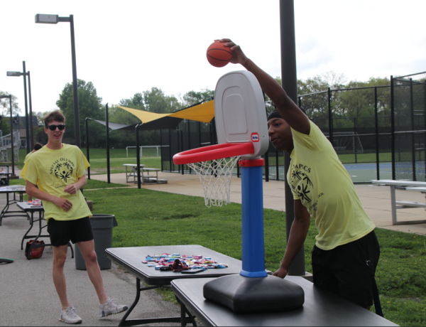 Victory village volunteers, Cooper Myers and Timothy Washington, help run the basketball stand for athletes.