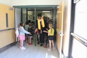 Senior, Akilesh Rajan, high-fives elementary schoolers at his visit at Ellisville Elementary.
