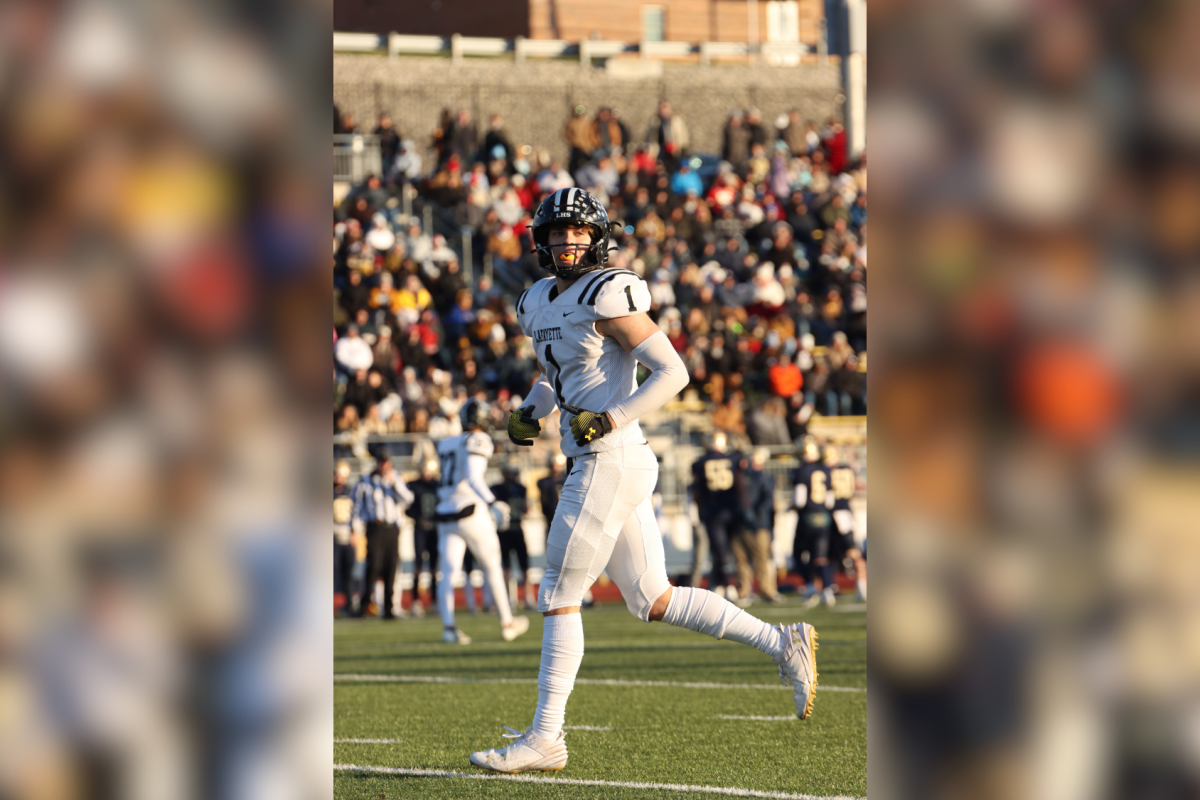 Jogging on the field, senior Robby Preckel lines up before a play. Preckel played in the State semifinal game against Helias Catholic that ended in a 14-13 loss, Nov. 29.