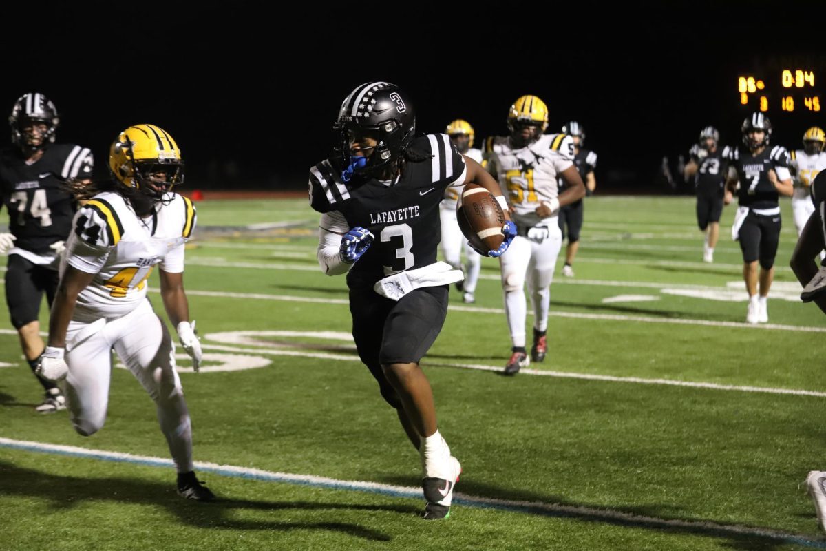 Running towards the end zone, senior wide reciever Terance Bills weaves his way past multiple Vikings on Friday, Sep. 5. Lafayette triumphed over Hazelwood Central, 49-0.