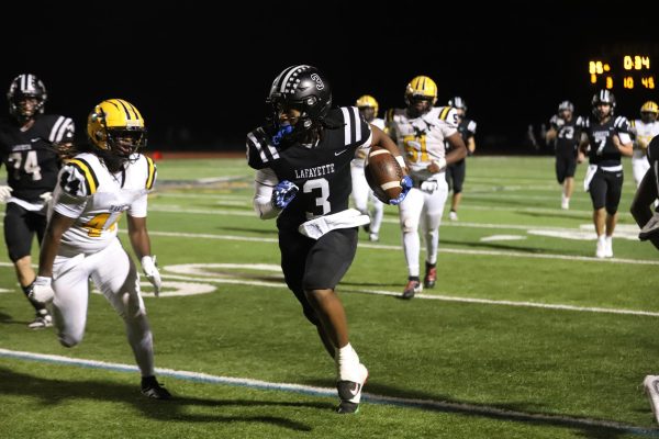 Running towards the end zone, senior wide reciever Terance Bills weaves his way past multiple Hawks on Friday, Sep. 5. Lafayette triumphed over Hazelwood Central, 49-0.