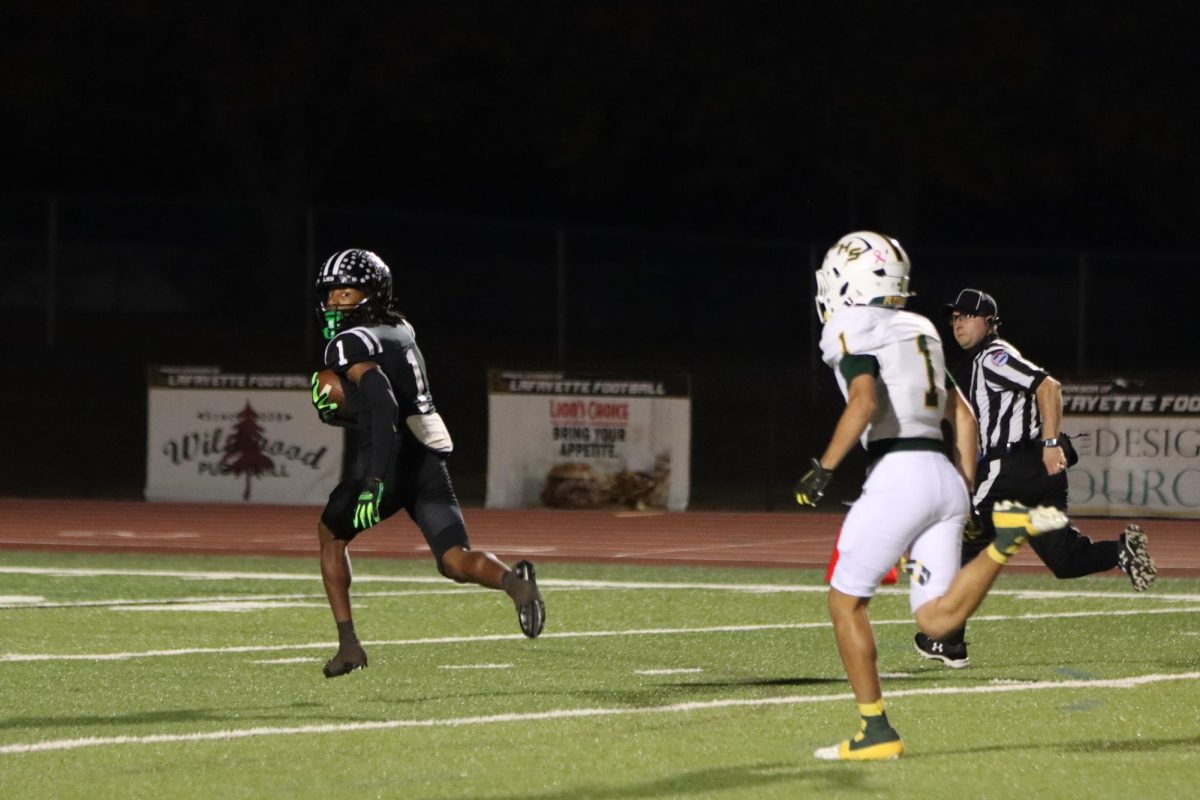 After recieving senior quarterback Brady Micek's pass, senior wide receiver Tim Washington runs the ball into the end zone on the first play of the game. Lafayette defeated Lindbergh, 54-14, on senior night Friday Oct. 17.