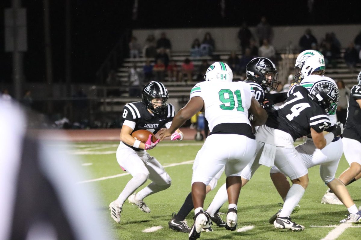 During a play, junior running back Cody Keen attempts to weave his way through multiple Marquette defenders with help from teammates. The Lancers defeated the Mustangs, 43-15, on Friday Oct. 24.
