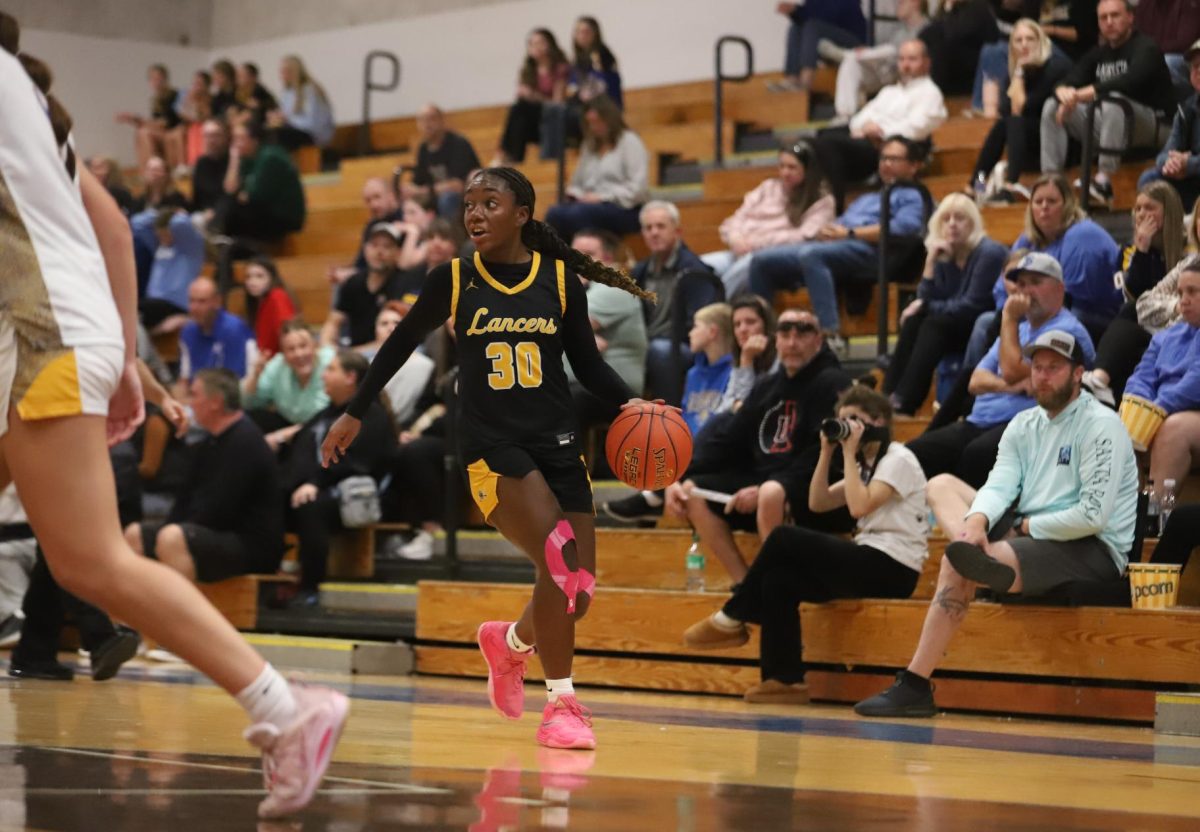 With the crowd looking on, sophomore guard Jasmyn Callaham dribbles down the side of the court. "I feel like we did a great job not crumbling under the pressure and making sure we made our shots," Callaham said about the team's overall performance.