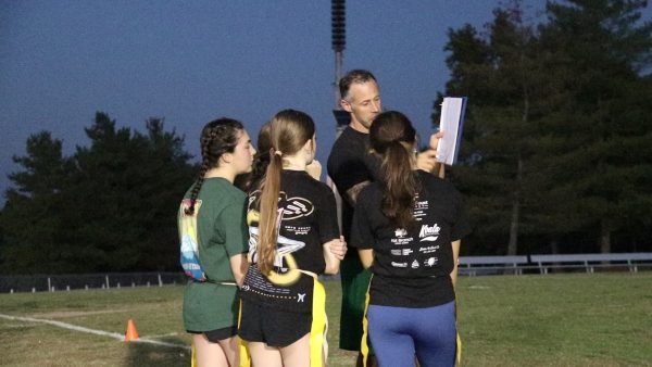 Offensive team goes over plays during a flag football practice