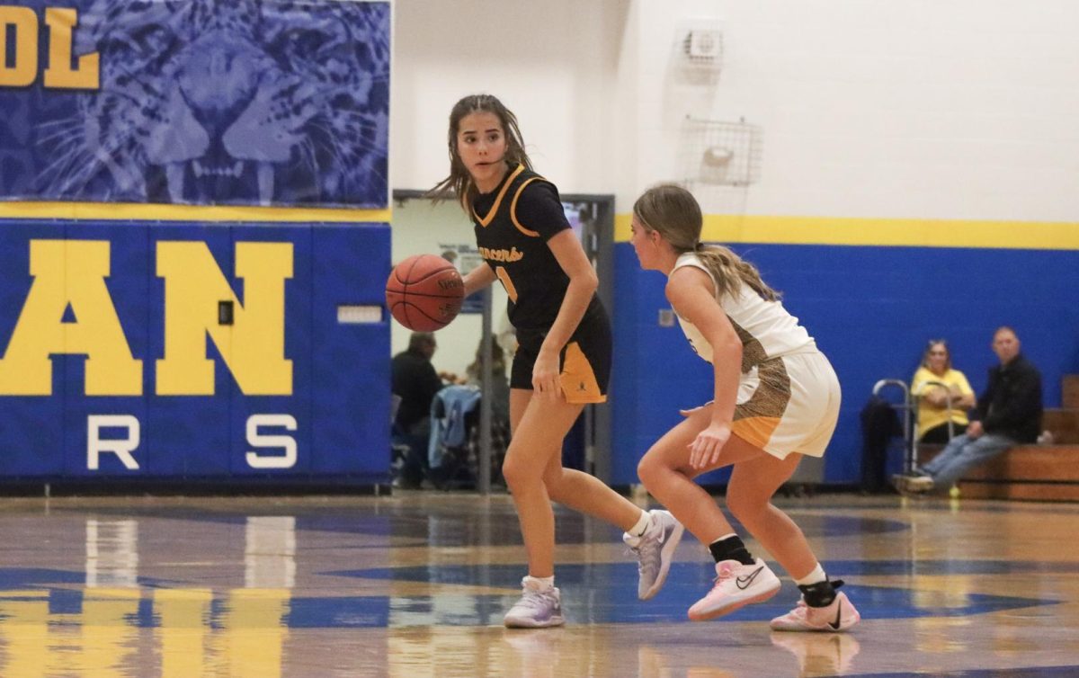 Keeping her defender at arm's length, junior guard Lylah Kimberlin dribbles upcourt. "I'm proud of my teammates for performing well under pressure," Kimberlin said, as the Lancers' short bench made the game more challenging.