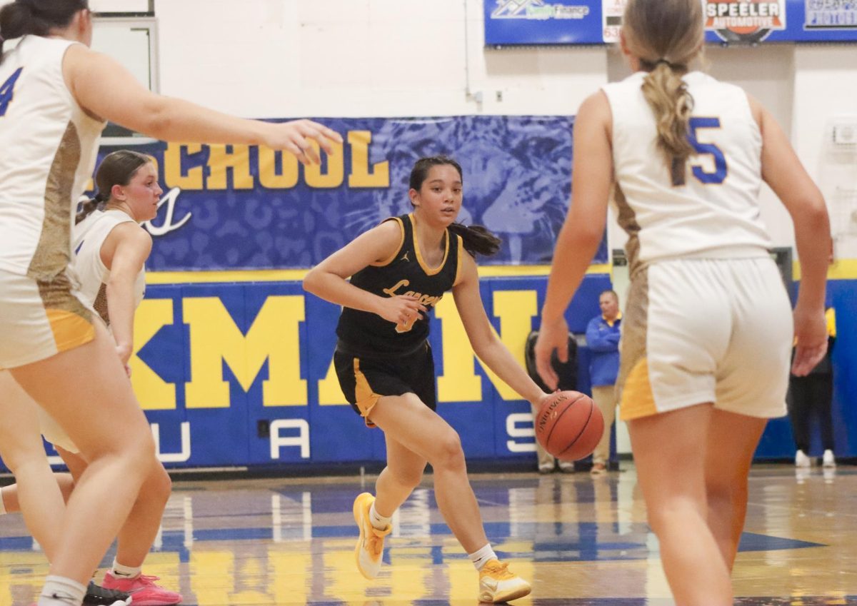 Surrounded by opponents, junior guard Maria Golfo looks for a pass. "I thought I played well. I made good passes," Golfo said.