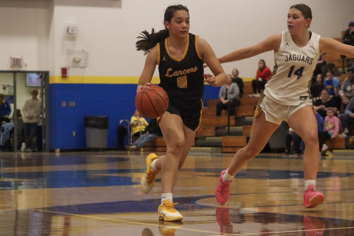 Trailed by an opponent, junior guard Maria Golfo races toward the hoop. Golfo is in her second year on varsity.