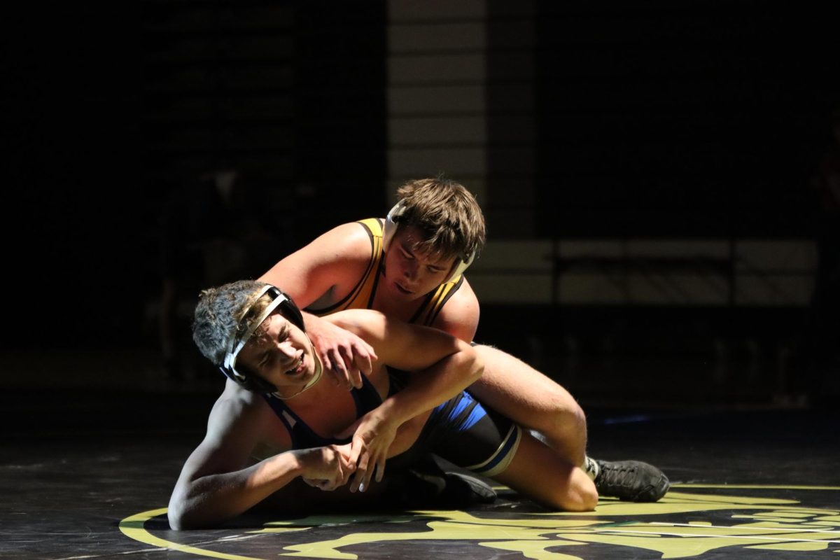 On the back of a Seckman wrestler, junior Tim Groff reaches over to gain hand control. Groff lost at the 175 pound weight class by a 10-5 decision.