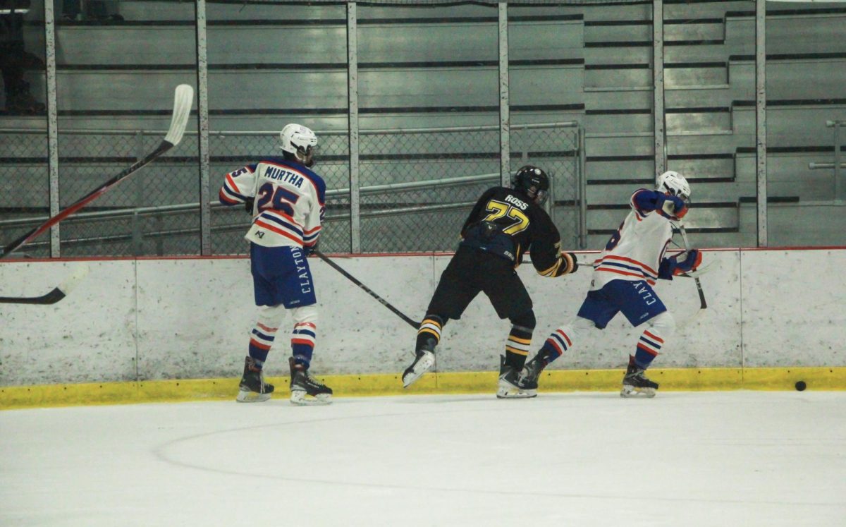 Caught between two guards, sophomore forward Luke Ross battles for the puck. Ross is playing for his second year on Lafayette.