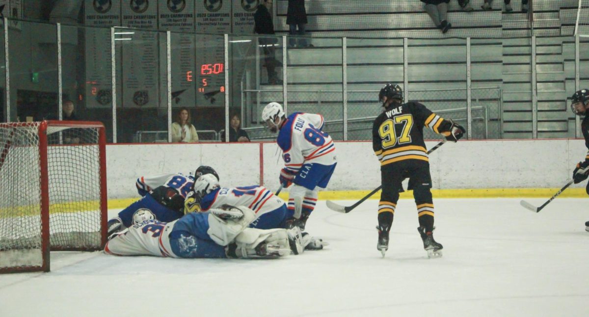As Clayton players pile up beside him, sophomore forward Vincent Wolf looks for an opening. Wolf assisted three teammates by the end of the game.