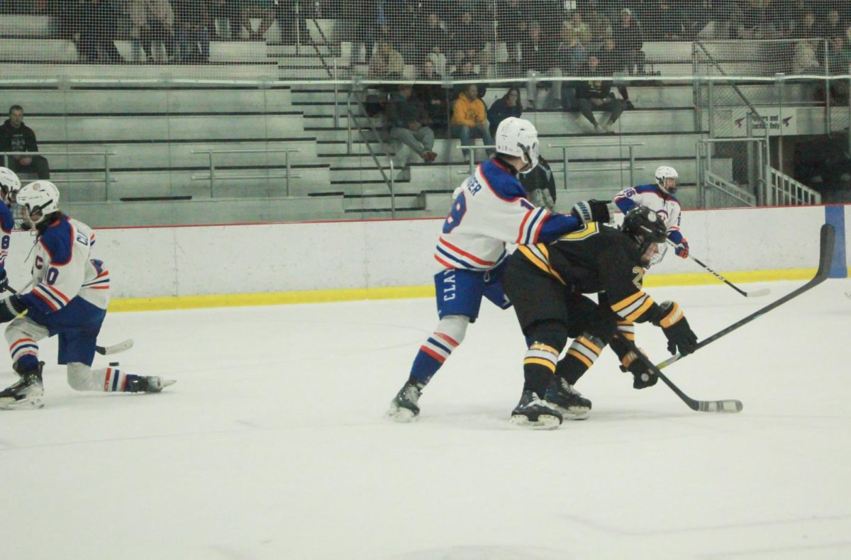 Colliding with a Clayton player, sophomore Luke Ross lurches forward. "Ross stepped up for us right away and scored three goals," coach Jim Carrico said.
