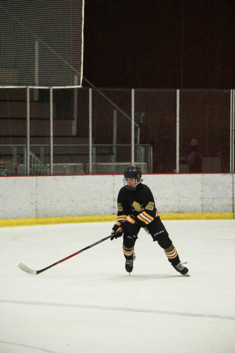 Eyes fixed on the puck, sophomore forward Quinn Thomas looks for an opening. Thomas made a goal shortly after, bringing the score to 4-1 early in the third quarter.