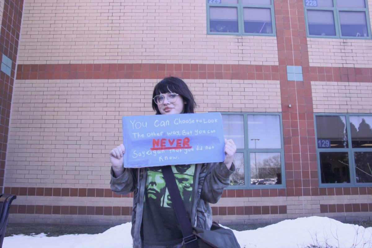 Standing in front of the school, freshman Sofia Pavia-Higel displays a message: "You can choose to look the other way, but you can NEVER say again that you did not know." Pavia-Higel was among the roughly 40 students attending the walkout.