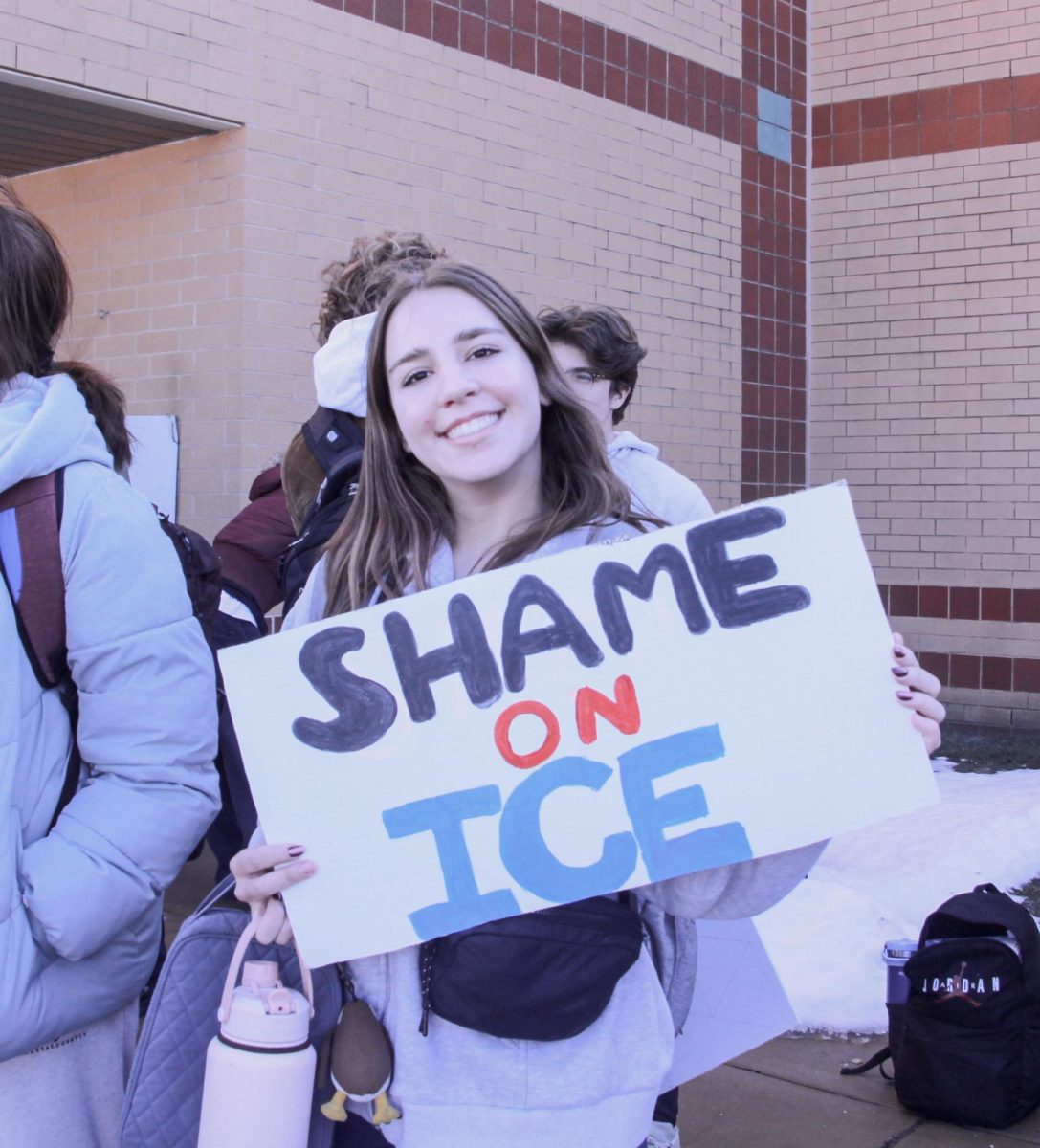 Holding a sign reading "Shame on ICE," sophomore Avory Wilson smiles. Wilson attended the protest with a few friends.
