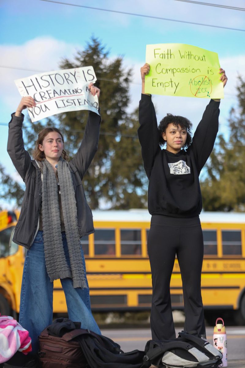 As cars pass Lafayette, sophomores Chelsea Akufuna and Zoe Faw raise signs to cars leaving the parking lot at the end of the school day Friday. "[Walking out] felt like the right thing to do, especially in the situation America is in right now," Faw said.